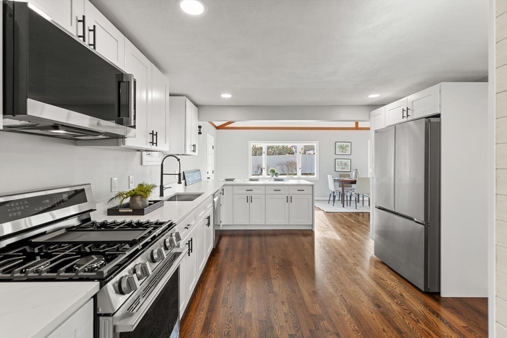 49 Butler Avenue Stoneham, MA 02180 - Photo 8 of 36 a kitchen with stainless steel appliances a stove a sink and a refrigerator