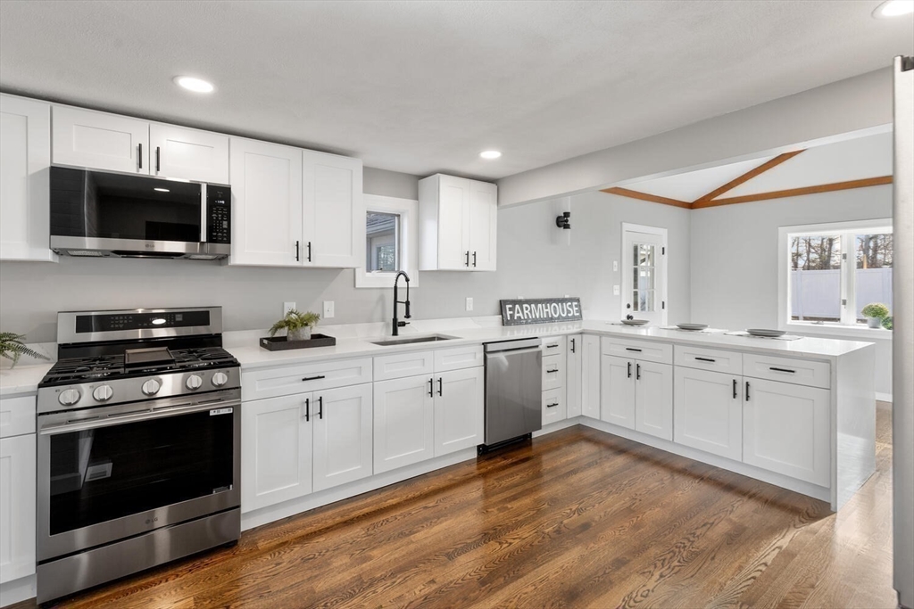 49 Butler Avenue Stoneham, MA 02180 - Photo 9 of 36 a kitchen with granite countertop white cabinets and stainless steel appliances