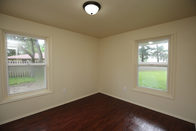 404 Hillside Road Joliet, IL 60433 - Photo 6 of 10 an empty room with wooden floor and windows