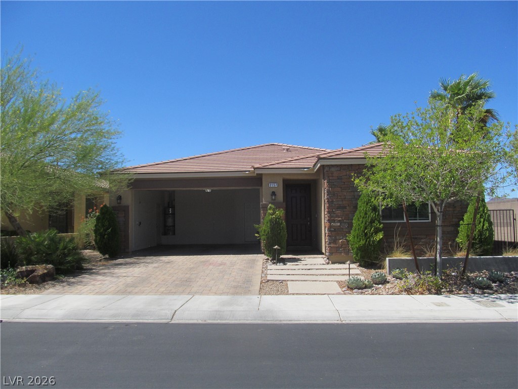 2157 Rio Rancho Pointe Place Henderson, NV 89002 - Photo 1 of 24 A terracotta-tiled roof crowns this residence, featuring a welcoming paved driveway and lush desert landscaping.
