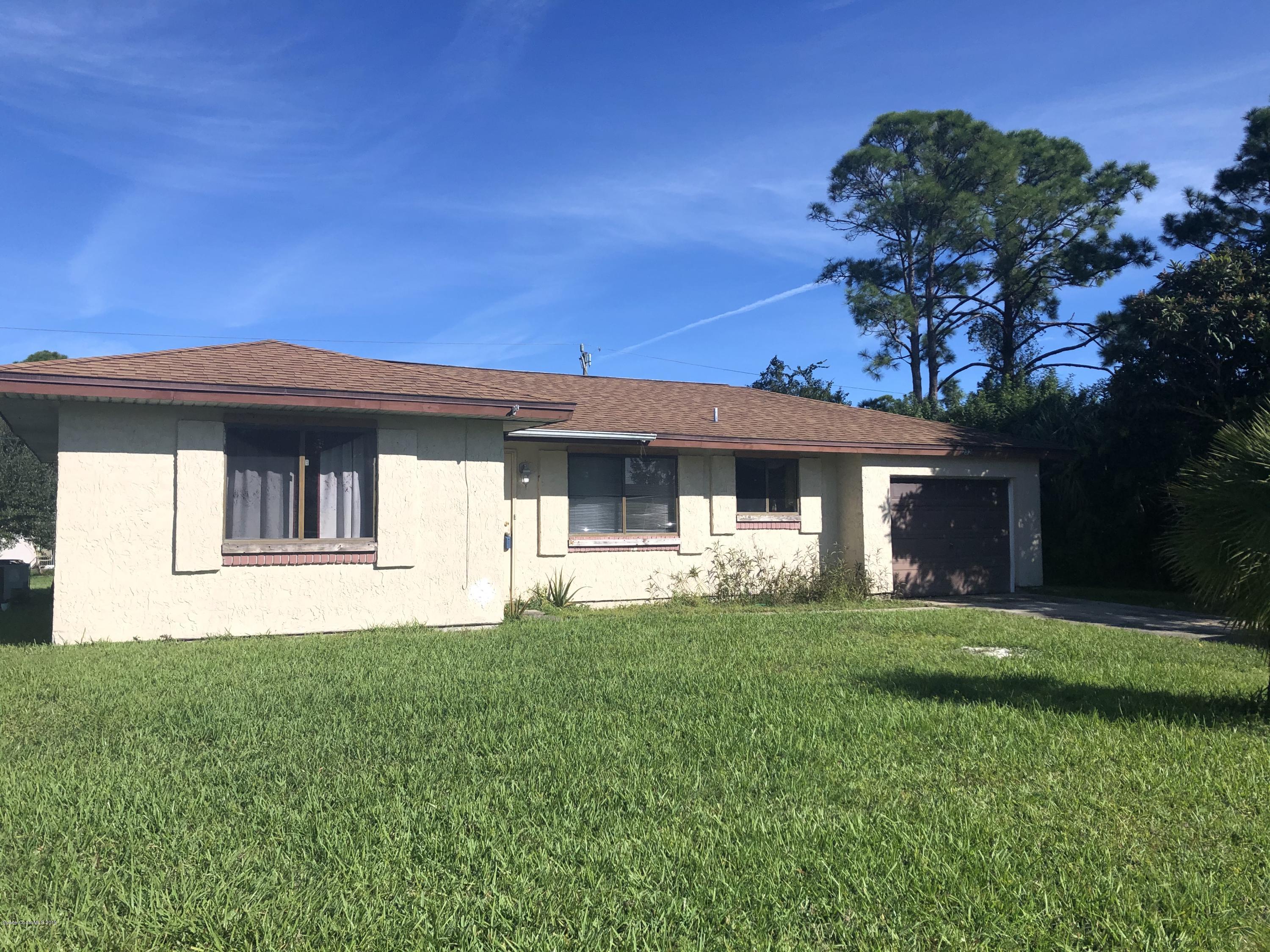 232 Abalone Road Northwest Palm Bay, FL 32907 - Photo 1 of 18 a front view of a house with a garden