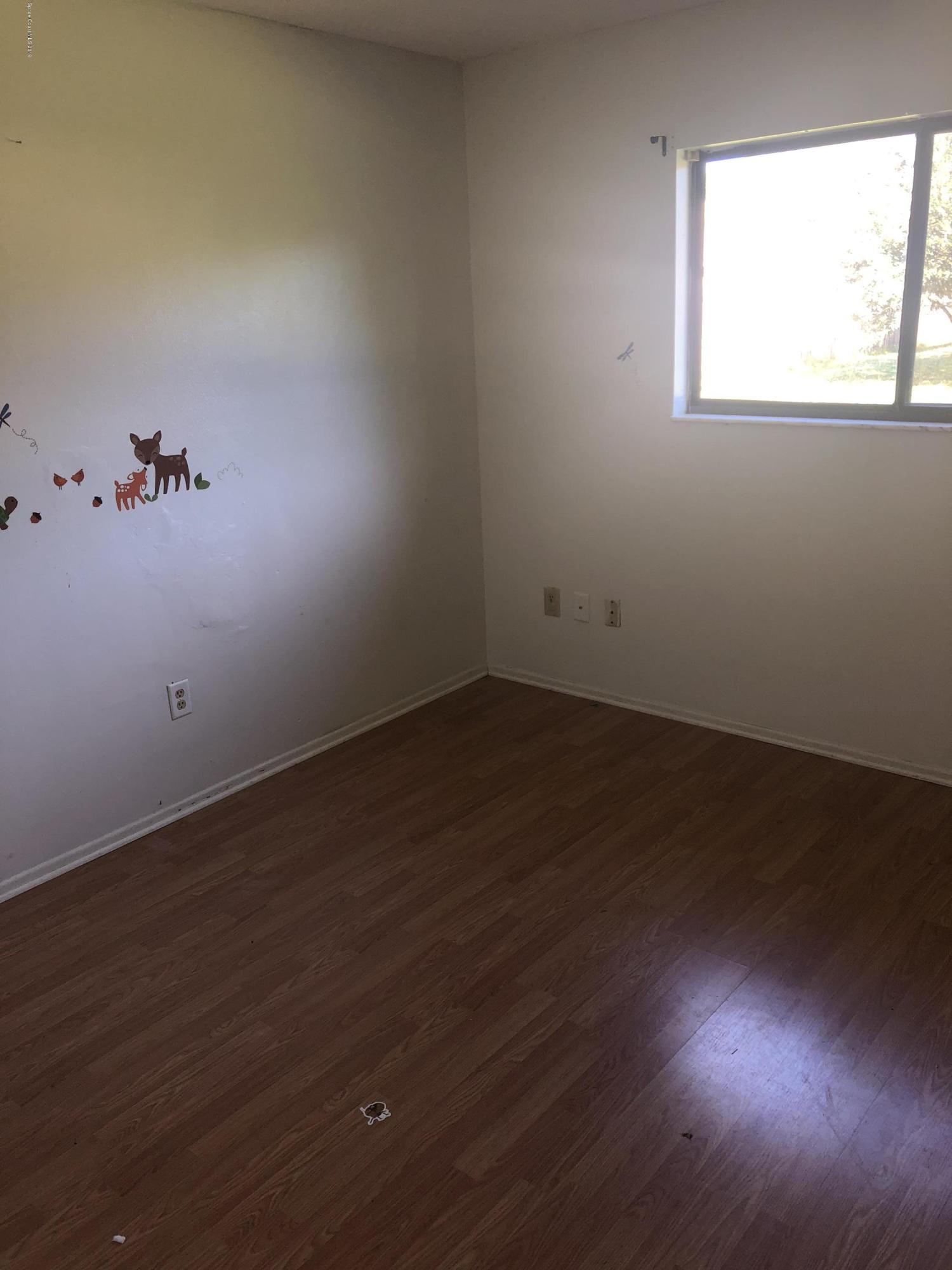 232 Abalone Road Northwest Palm Bay, FL 32907 - Photo 11 of 18 an empty room with wooden floor and windows