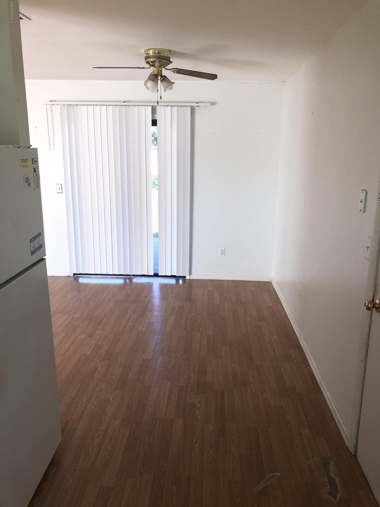232 Abalone Road Northwest Palm Bay, FL 32907 - Photo 14 of 18 an empty room with wooden floor and windows