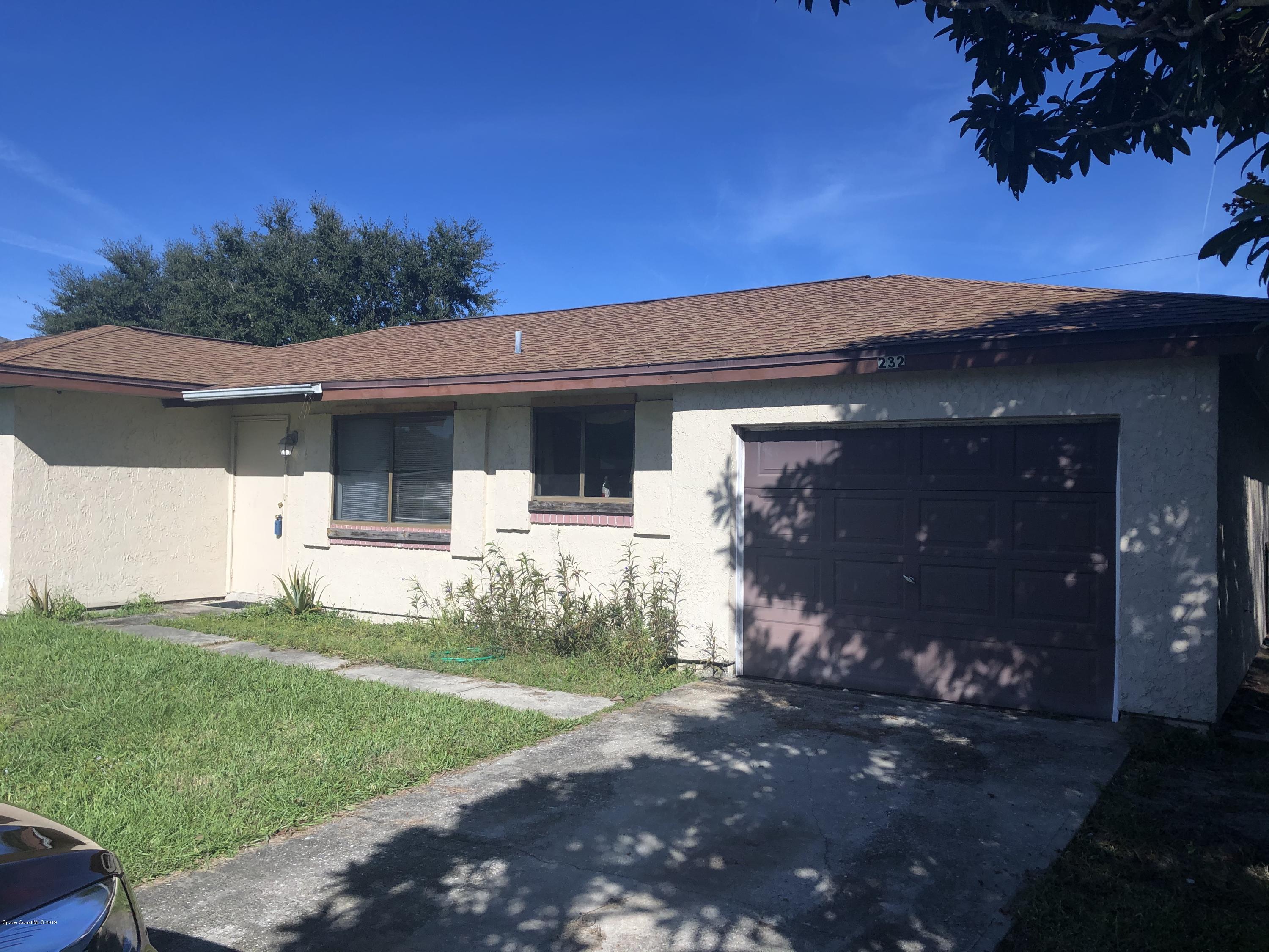 232 Abalone Road Northwest Palm Bay, FL 32907 - Photo 3 of 18 a front view of a house with a yard