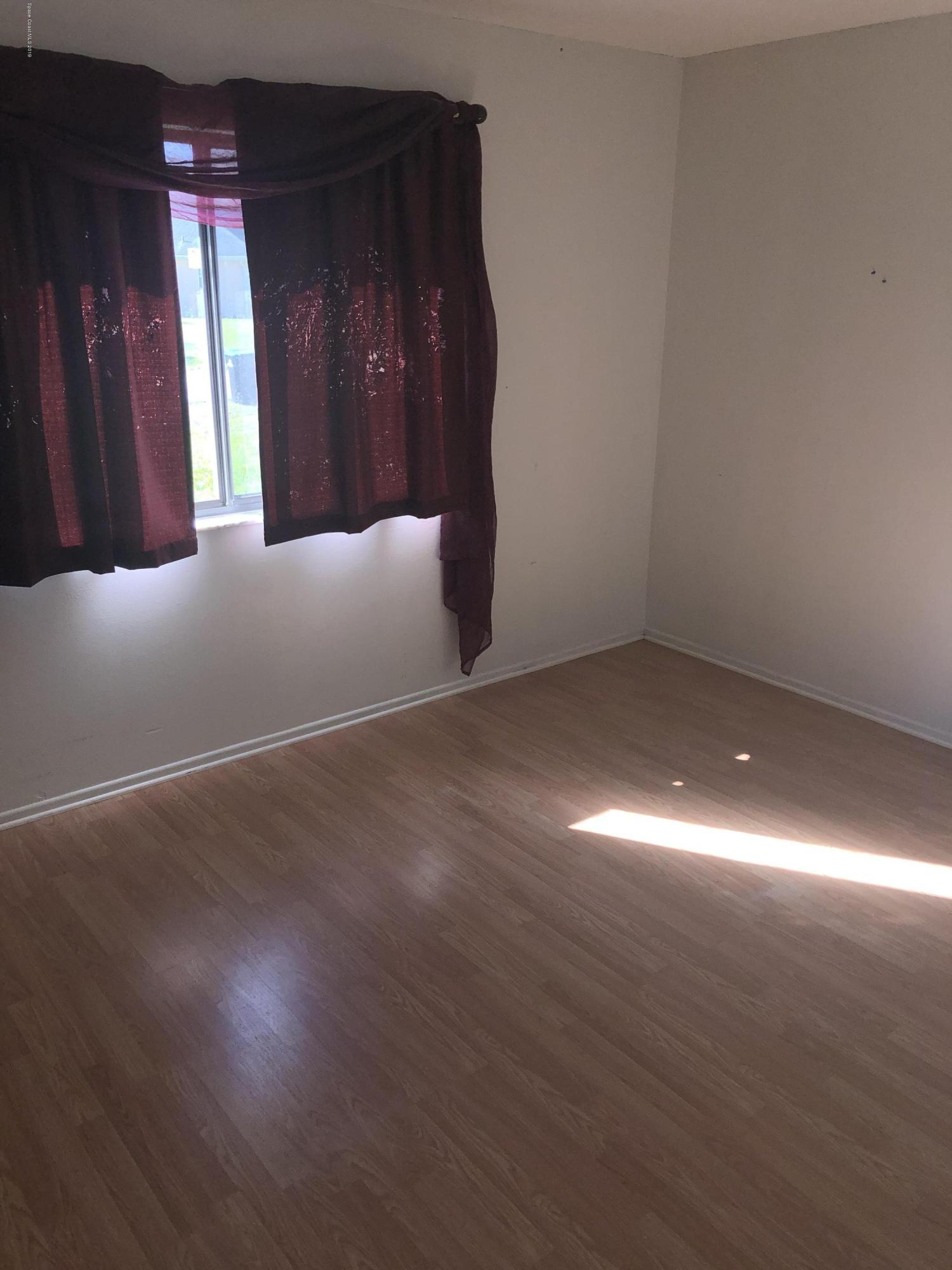 232 Abalone Road Northwest Palm Bay, FL 32907 - Photo 8 of 18 a view of a hallway with wooden floor and front door