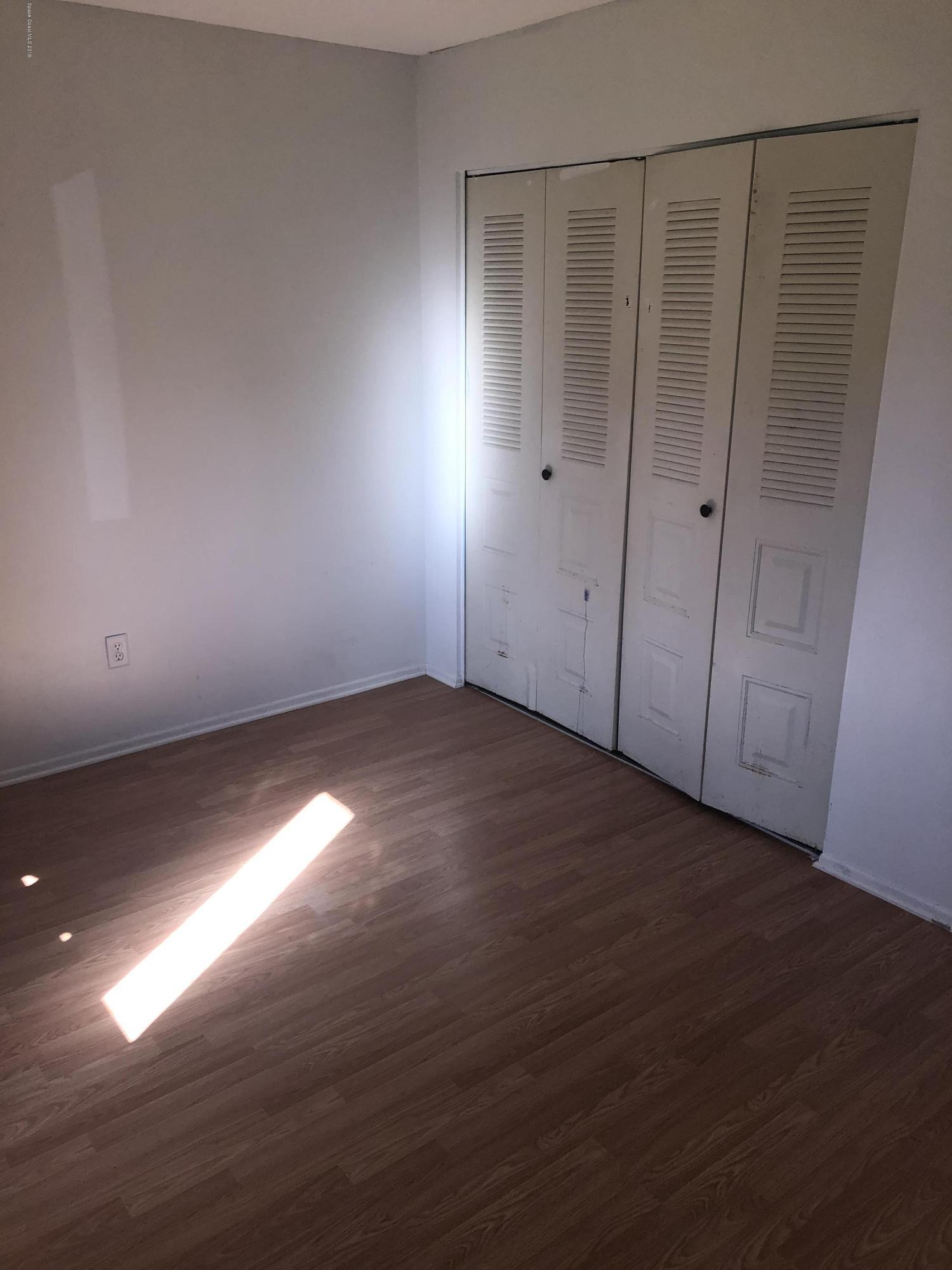 232 Abalone Road Northwest Palm Bay, FL 32907 - Photo 9 of 18 a view of an empty room with wooden floor and a window