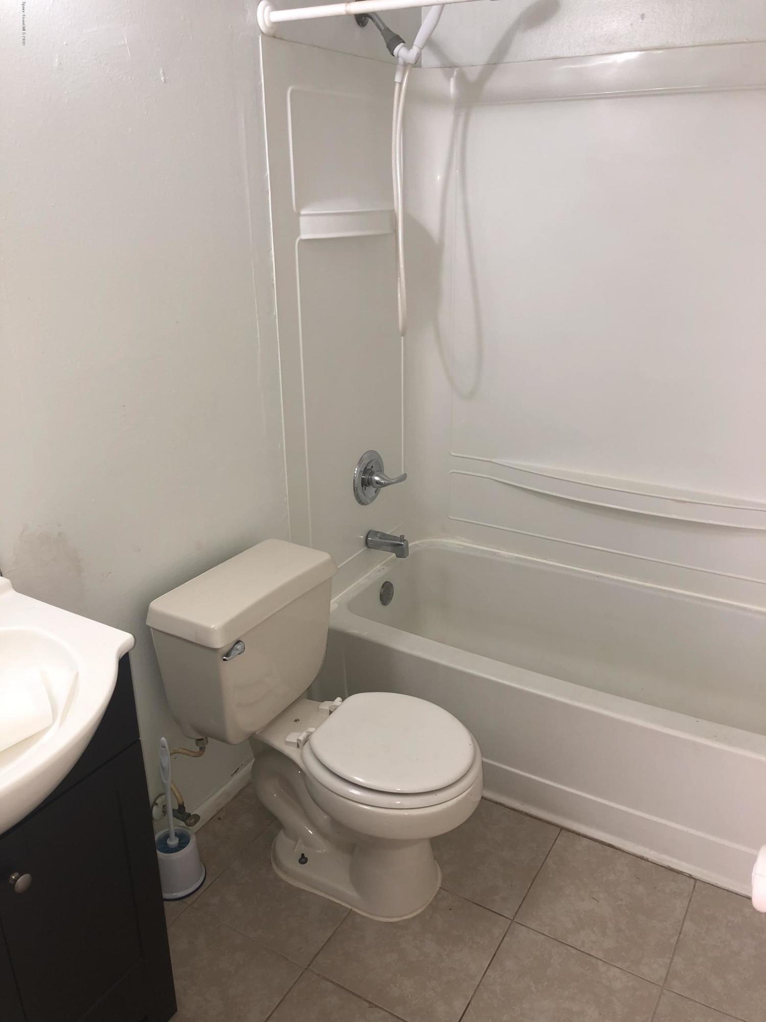 232 Abalone Road Northwest Palm Bay, FL 32907 - Photo 10 of 18 a white toilet and tub next to a bathroom sink