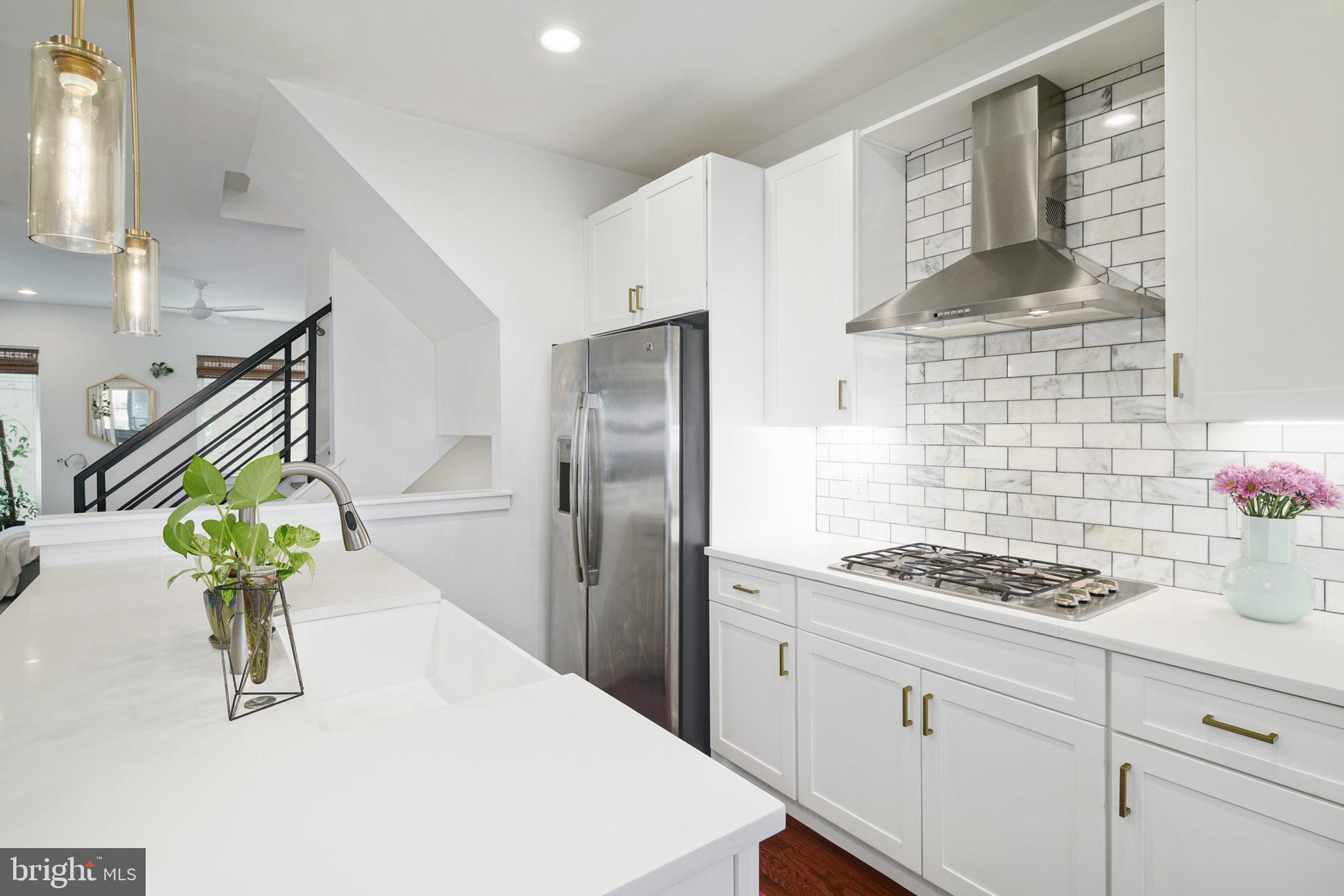 159 East Allen Street, Unit 1 Philadelphia, PA 19125 - Photo 22 of 45 a kitchen with stainless steel appliances kitchen island granite countertop a refrigerator a stove a sink a counter space and cabinets