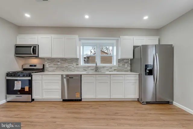 a kitchen with stainless steel appliances granite countertop a stove a sink and a refrigerator