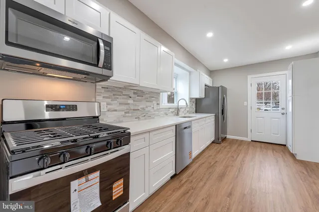 a kitchen with stainless steel appliances kitchen island wooden cabinets and a stove top oven