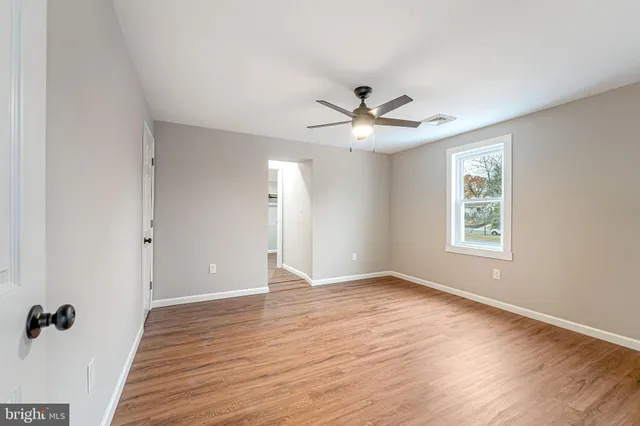 wooden floor in an empty room with a window