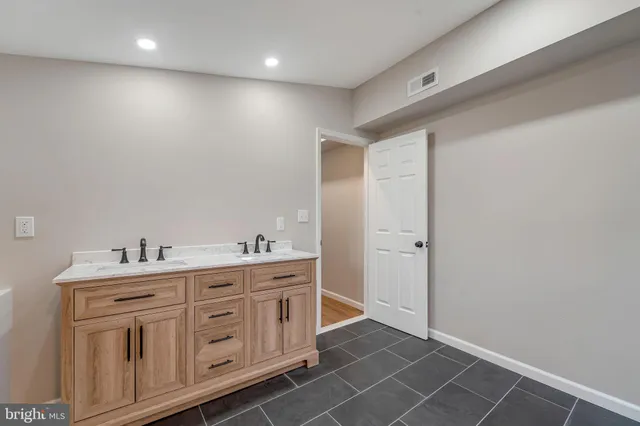 a bathroom with a double vanity sink a mirror and a shower