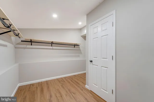 a view of walk in closet with empty racks