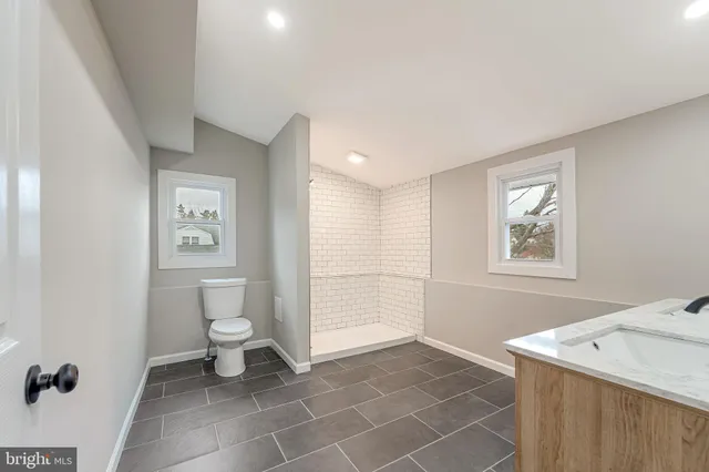 a bathroom with a sink a toilet and a window