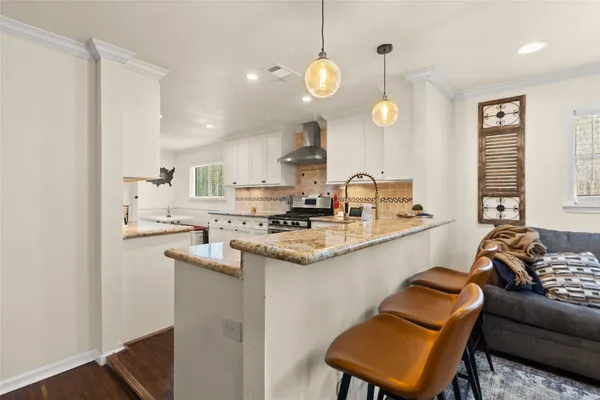 a kitchen with stainless steel appliances granite countertop a sink a stove and a refrigerator