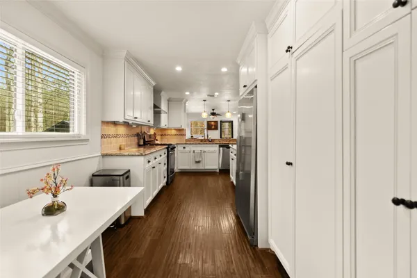 a kitchen with a sink appliances cabinets and a window