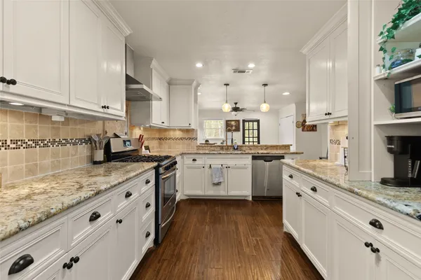 a kitchen with granite countertop white cabinets and white appliances