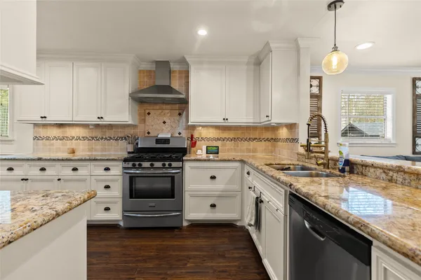 a kitchen with granite countertop a sink stove and cabinets