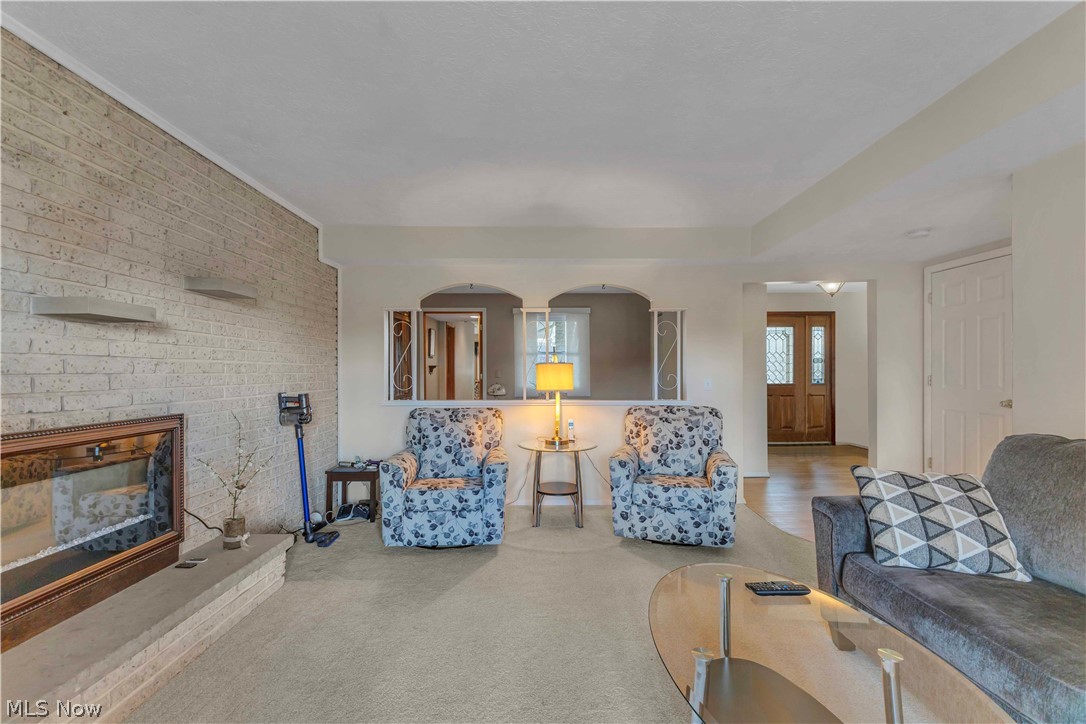 563 North Carpenter Road Brunswick, OH 44212 - Photo 2 of 45 Carpeted living area featuring a fireplace and brick wall