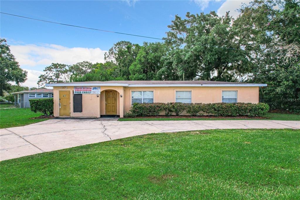 825 North Pine Hills Road Orlando, FL 32808 - Photo 4 of 8 a view of a house with a yard and a large tree