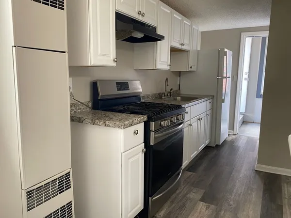 a kitchen with stainless steel appliances granite countertop a refrigerator a stove a sink and a microwave