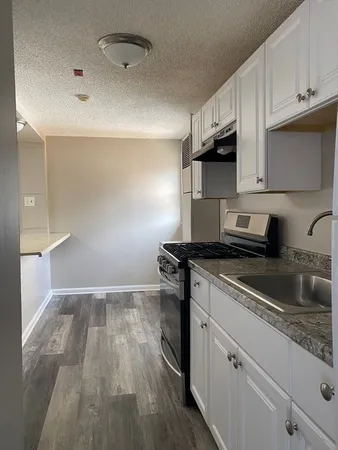 a kitchen with granite countertop a sink stainless steel appliances and cabinets