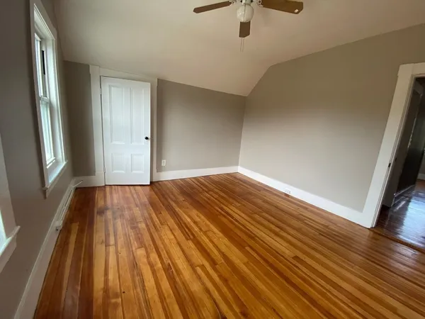 a view of empty room with wooden floor