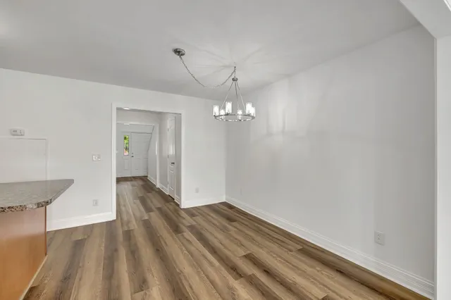 a view of a room with wooden floor and chandelier