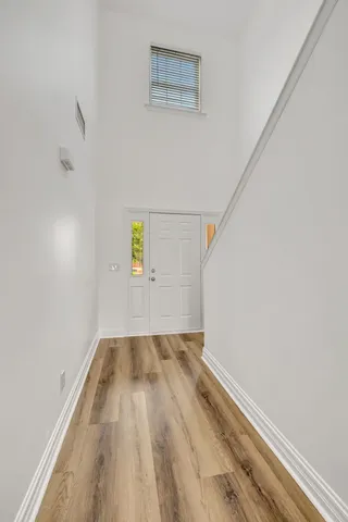 a view of an empty room with wooden floor