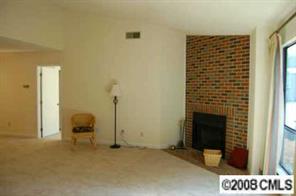 1606 Sharon Road West, Unit 34W Charlotte, NC 28210 - Photo 2 of 8 a view of an empty room with a fireplace and wooden floor