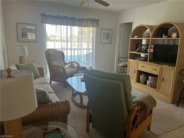 a living room with furniture a window and a flat screen tv