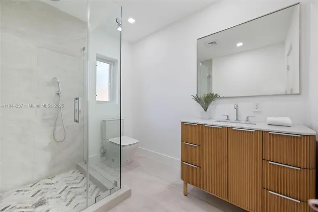 a bathroom with a double vanity sink mirror and toilet