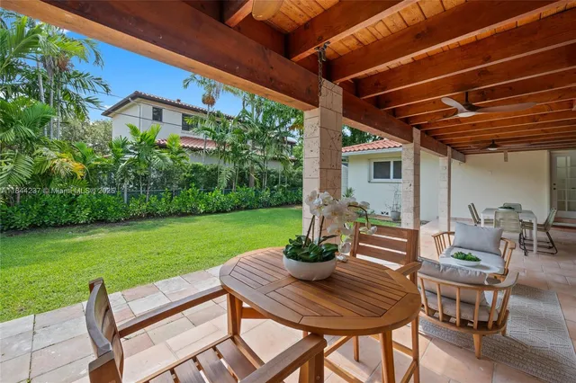 a view of a patio with table and chairs and potted plants with wooden floor and fence