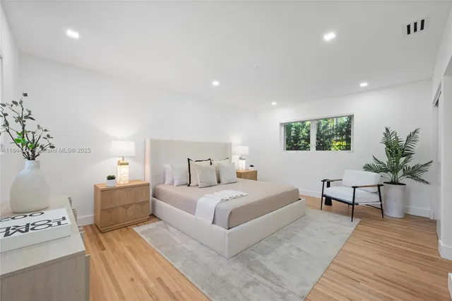 a bedroom with a large bed and a potted plant