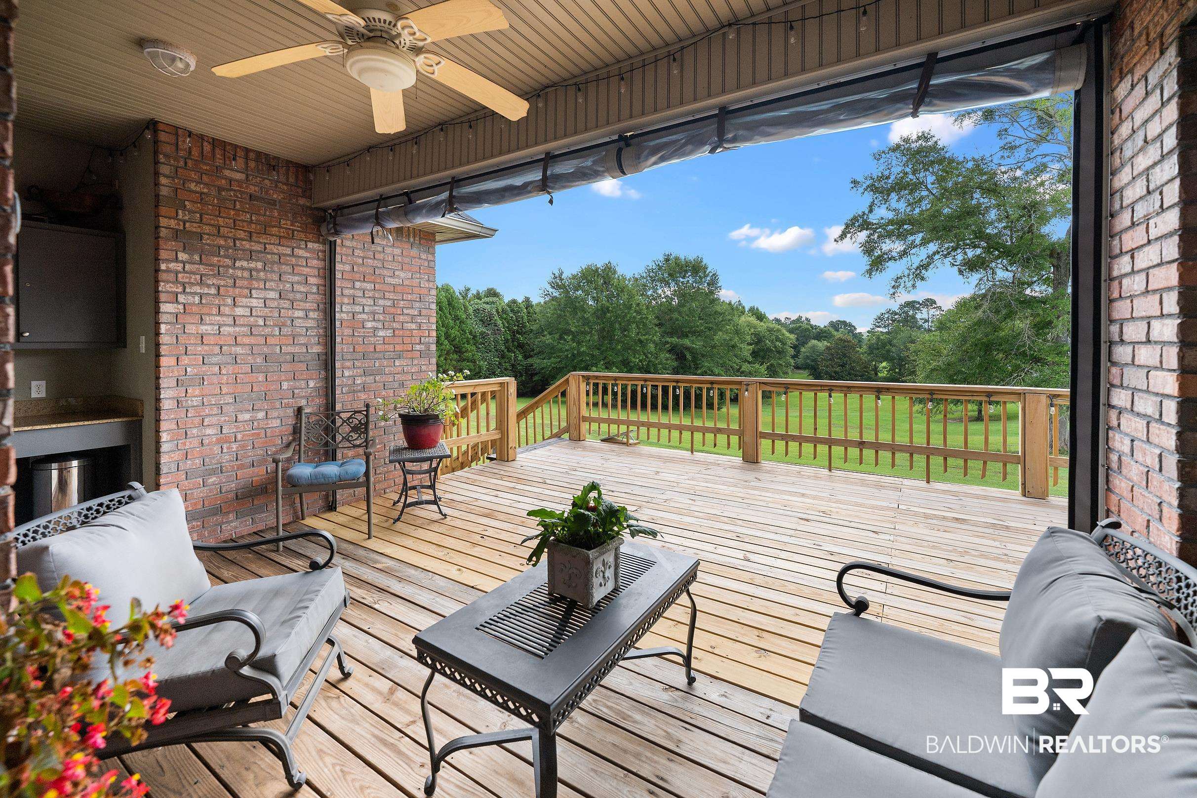 197 Morning Ridge Road Monroeville, AL 36460 - Photo 43 of 51 Expansive outdoor deck featuring wood flooring, a ceiling fan, and a built-in outdoor kitchen with a stone countertop