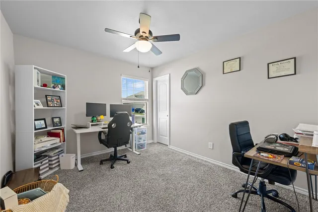 a view of a workspace with furniture and a window