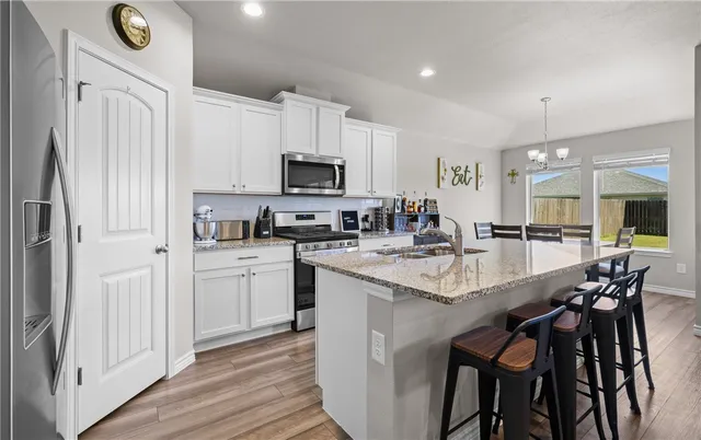 a kitchen with appliances a sink and cabinets
