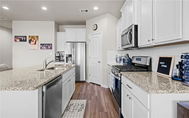 a kitchen with granite countertop a sink stove and refrigerator