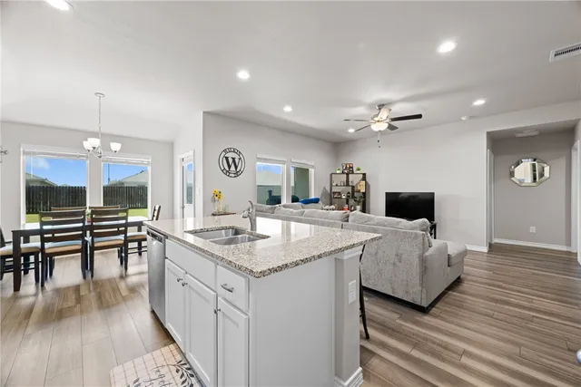 a large white kitchen with a large island in the center