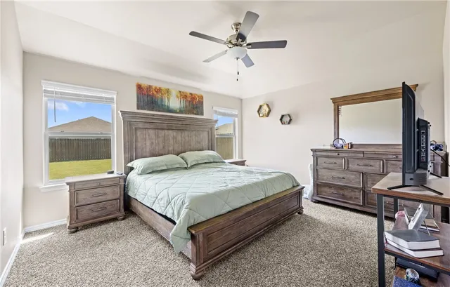 a bedroom with a bed and a flat tv screen on dresser