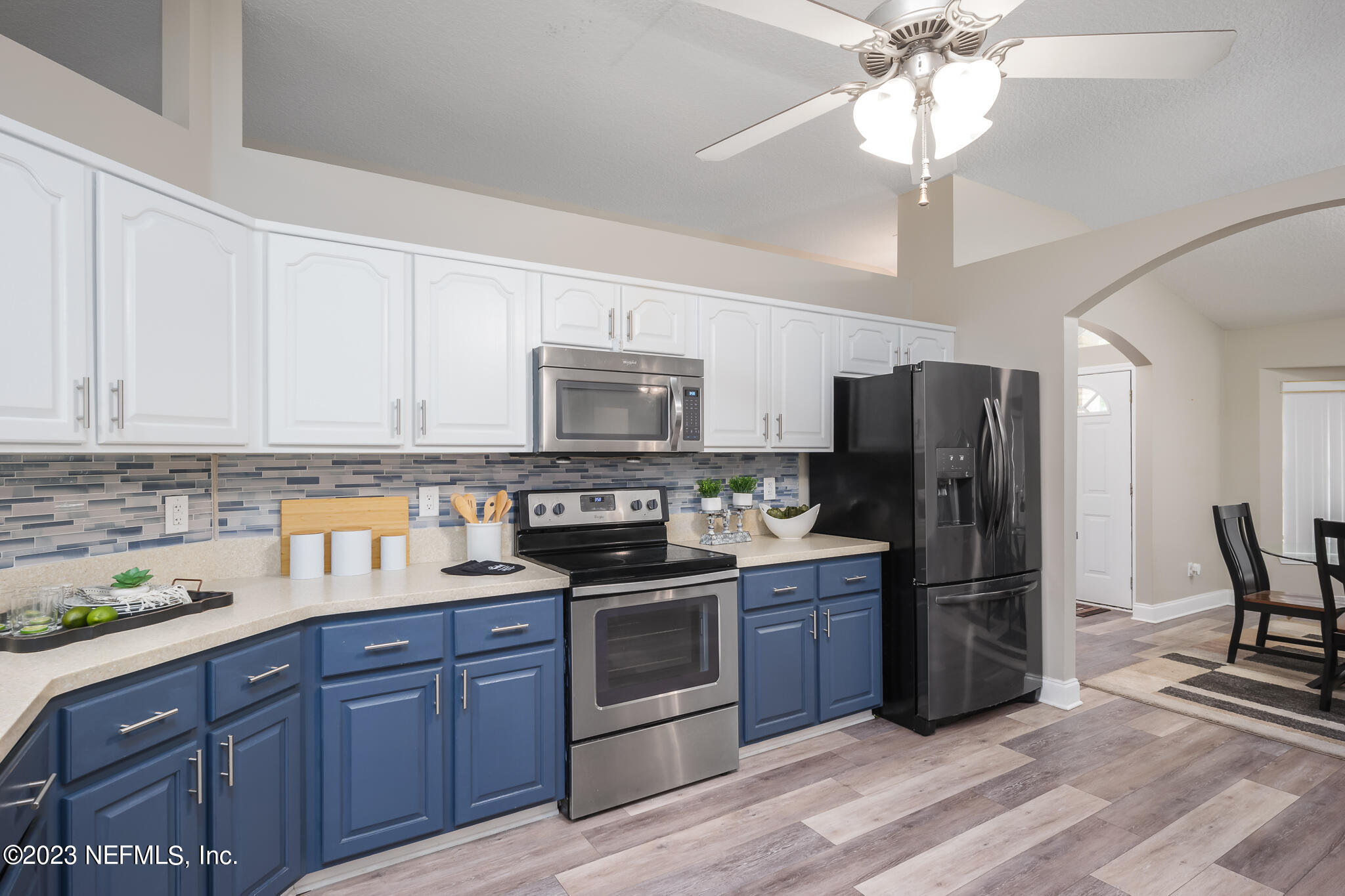 775 Camp Francis Johnson Road Orange Park, FL 32065 - Photo 11 of 41 a kitchen with stainless steel appliances granite countertop a refrigerator a stove a sink dishwasher and white cabinets with wooden floor
