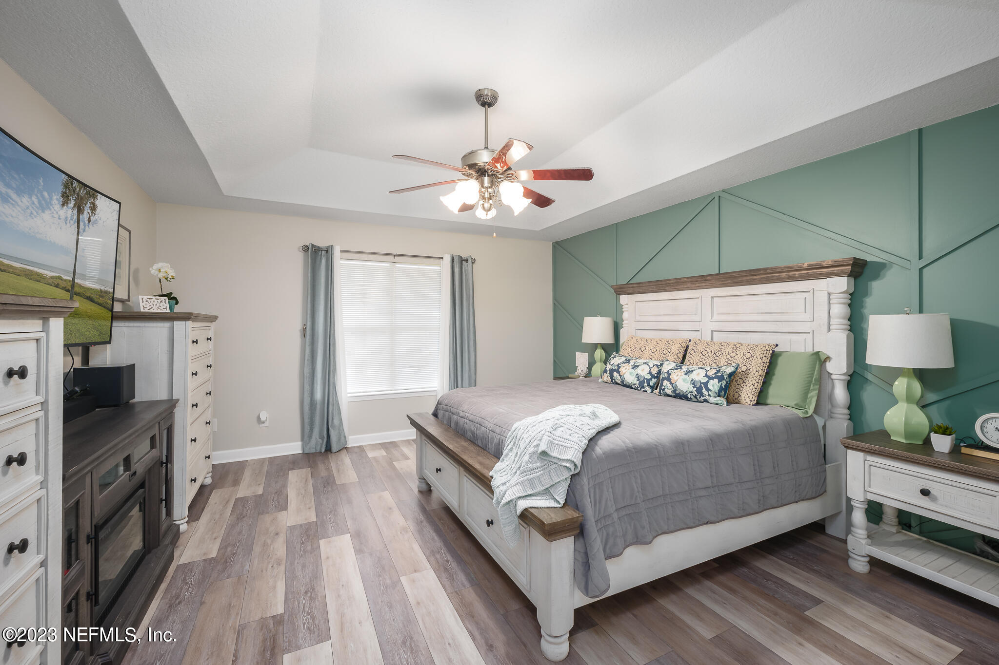 775 Camp Francis Johnson Road Orange Park, FL 32065 - Photo 19 of 41 a bedroom with a bed chandelier and a fireplace