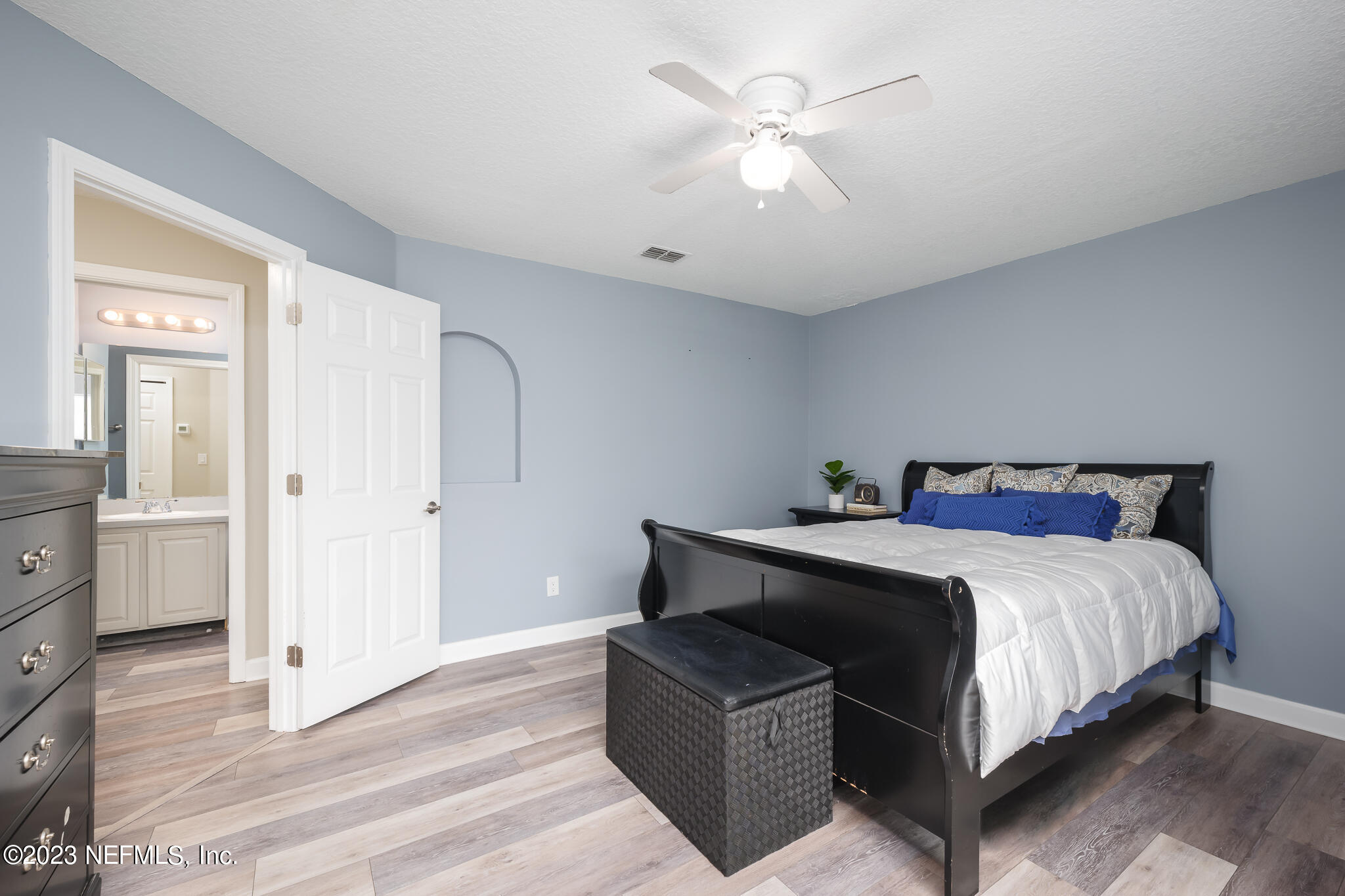 775 Camp Francis Johnson Road Orange Park, FL 32065 - Photo 29 of 41 a spacious bedroom with a bed and a chandelier