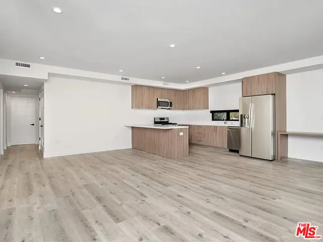 a kitchen with stainless steel appliances a refrigerator and a microwave