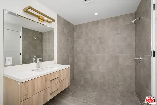 a bathroom with a sink a mirror and a shower