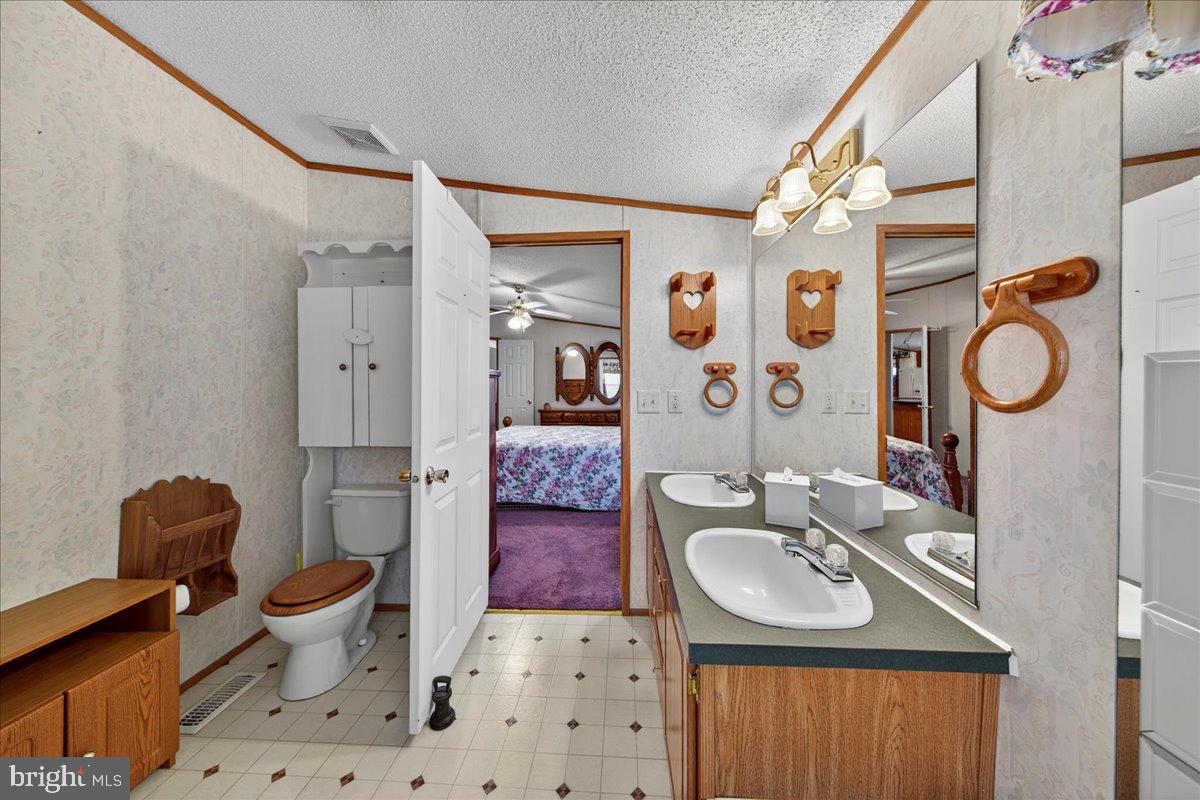 220 Chalklevel Road Louisa, VA 23093 - Photo 32 of 63 a bathroom with a sink toilet mirror vanity and shower