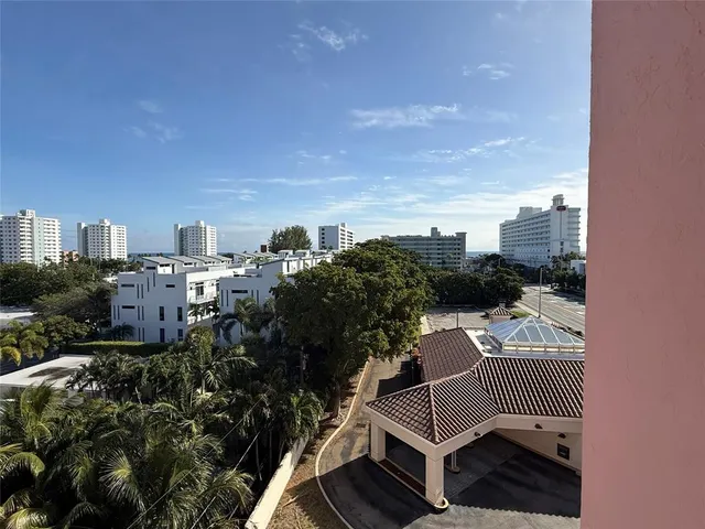a bedroom with a bed a flat screen tv and a window