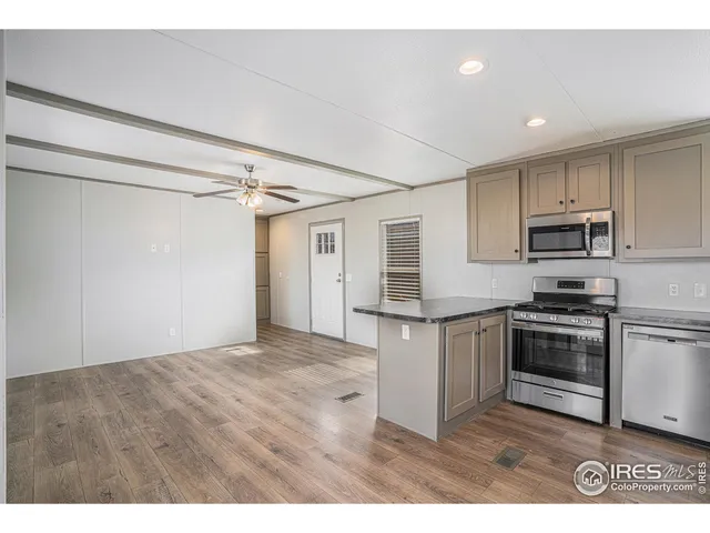 a kitchen with kitchen island granite countertop a sink cabinets and stainless steel appliances