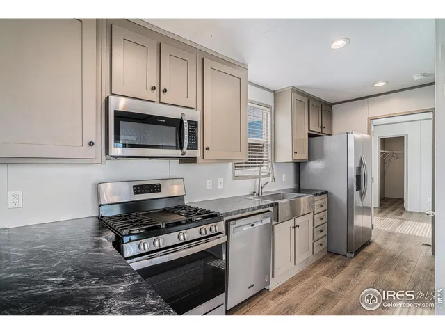 a kitchen with stainless steel appliances granite countertop a stove a sink and a microwave