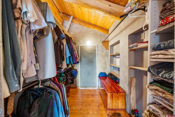 a view of walk in closet with clothes and shoes